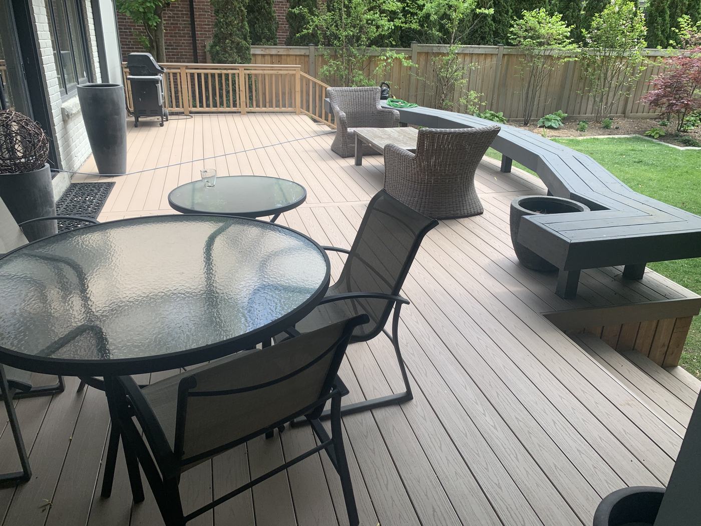Composite deck with curved built-in bench and wicker lounge seating