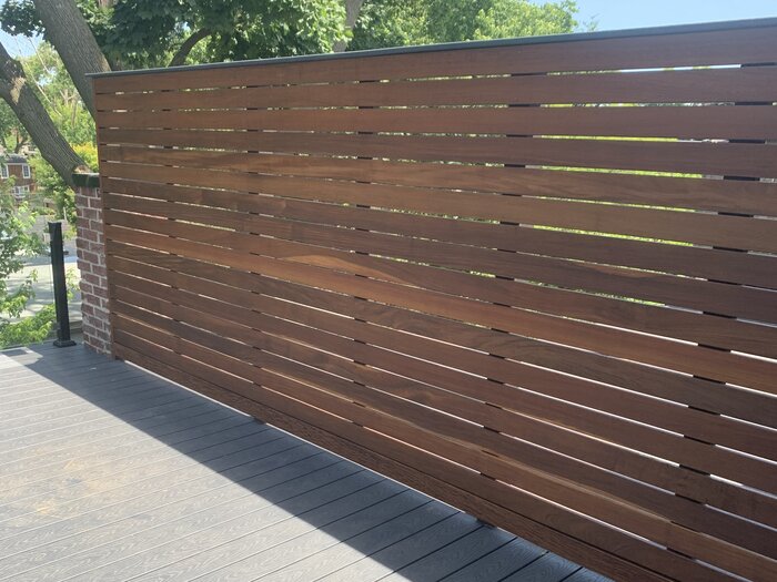Horizontal-slat wood privacy wall on an elevated composite deck