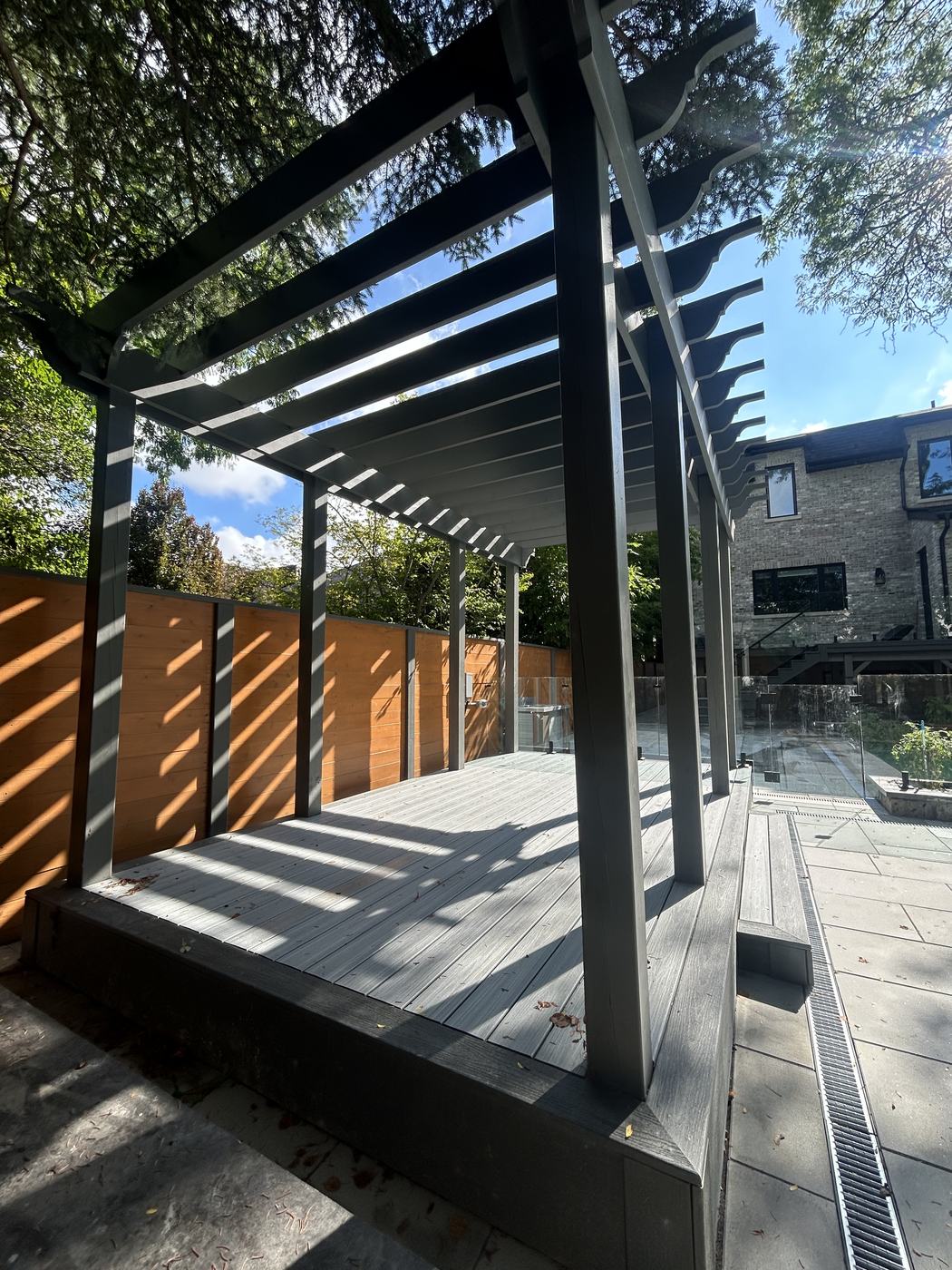 Pergola framing under construction with glass railing