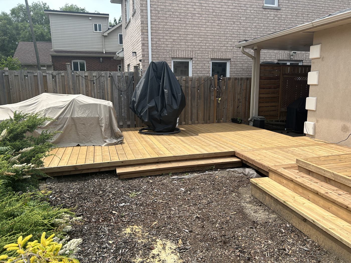 Wood deck with covered furniture and privacy screen