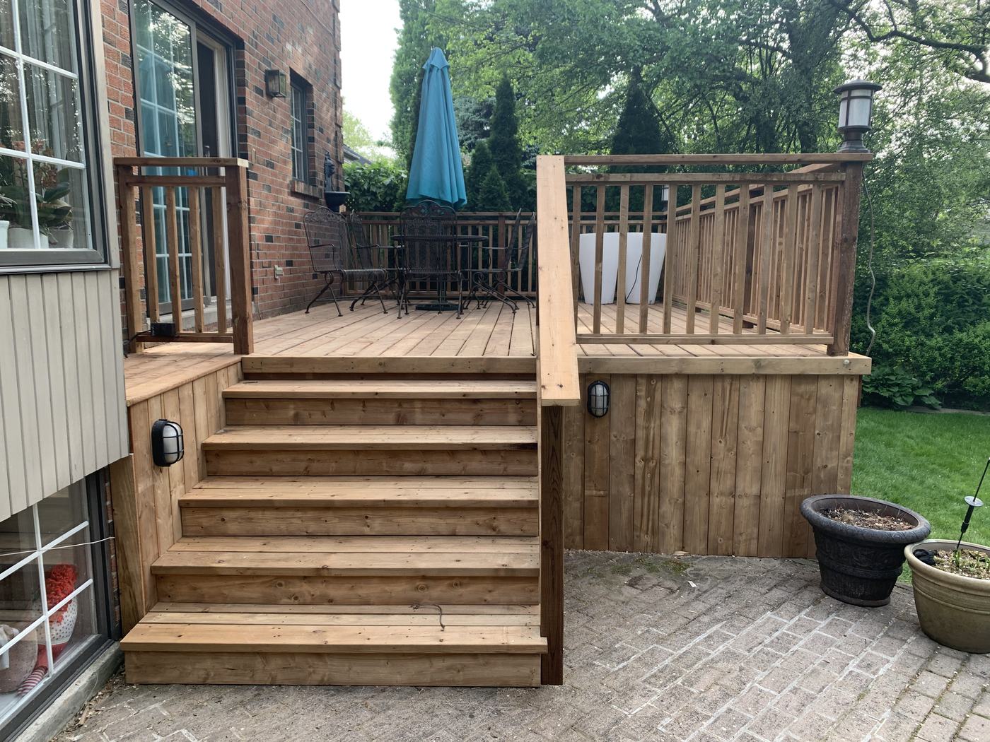 Pressure-treated deck with wrought iron dining set and umbrella